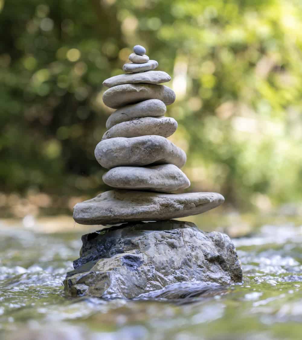 vertical-shot-pyramid-stones-balanced-river-water